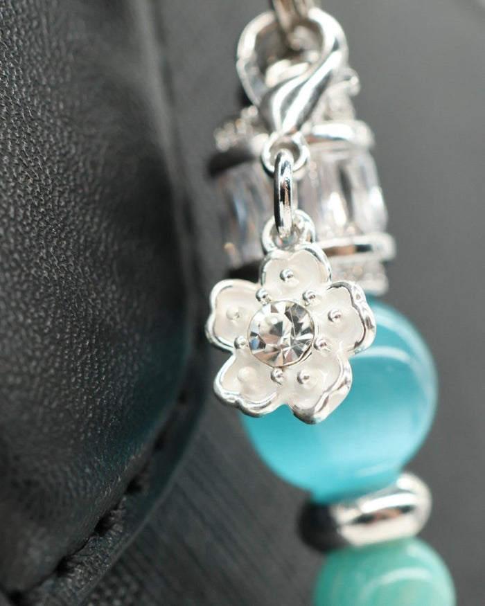 LD Keyfinder Azure Meadow bracelet with aqua blue cat's eye beads, Amazonite, glass beads, and a white daisy charm with crystal.