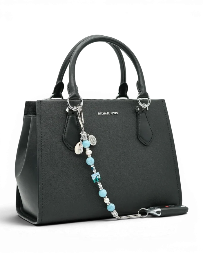 LD Keyfinder Beachy Dreams keychain with teal, blue, and white beads, freshwater pearls, and charms on a black handbag.