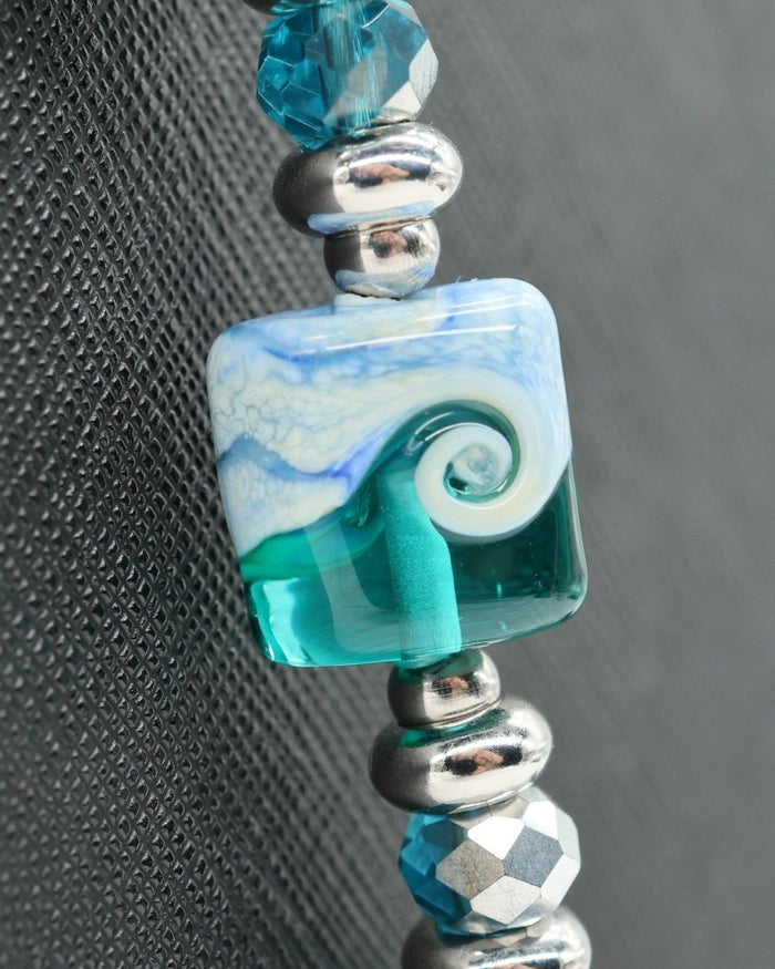 LD Keyfinder Beachy Dreams bracelet with teal, blue, and white glass bead, imitation larimar, faceted blue glass, freshwater pearls, and silver spacers.