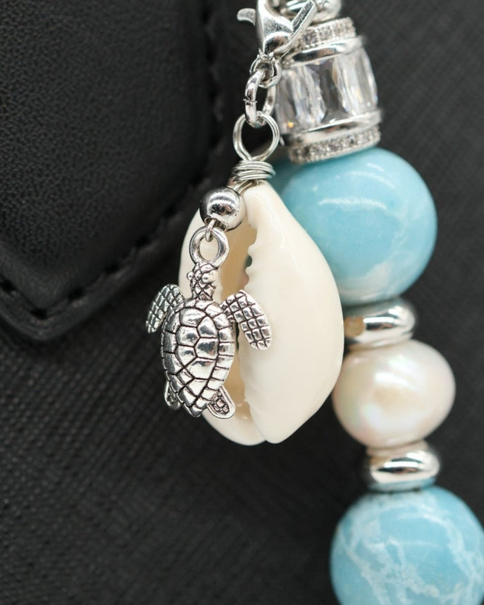 LD Keyfinder Beachy Dreams keychain with a silver turtle charm, cowrie shell, freshwater pearl, and blue imitation larimar beads.