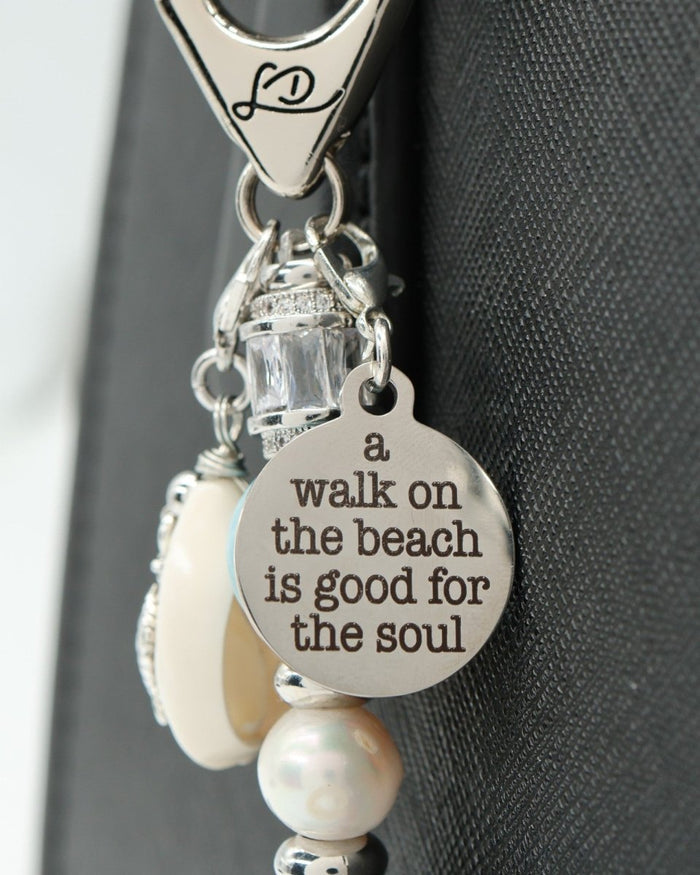 LD Keyfinder Beachy Dreams keychain with a round charm engraved "a walk on the beach is good for the soul", pearl, blue stone, and turtle charm.