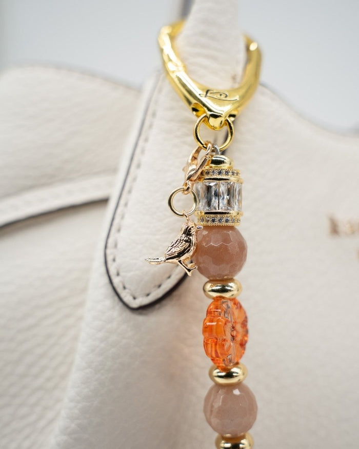 LD Keyfinder Birdsong Bliss featuring sunstone, coral flower beads, and a gold-plated bird charm on a gold clasp.