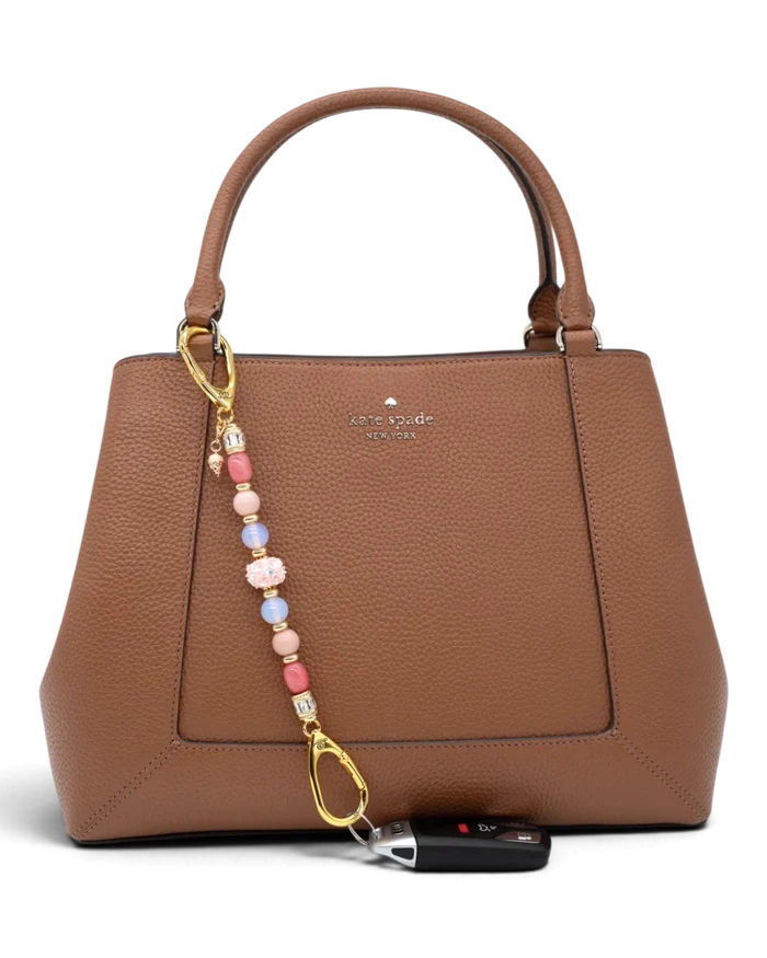 LD Keyfinder Blush Sorbetto beaded accessory with pink gemstones and ice cream charm attached to a brown leather bag