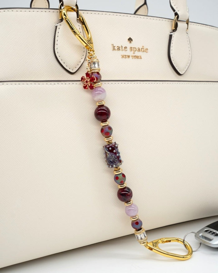 LD Keyfinder Bordeaux Bloom artisan beaded bag charm with burgundy agate, kunzite, and gold-plated flower charm.