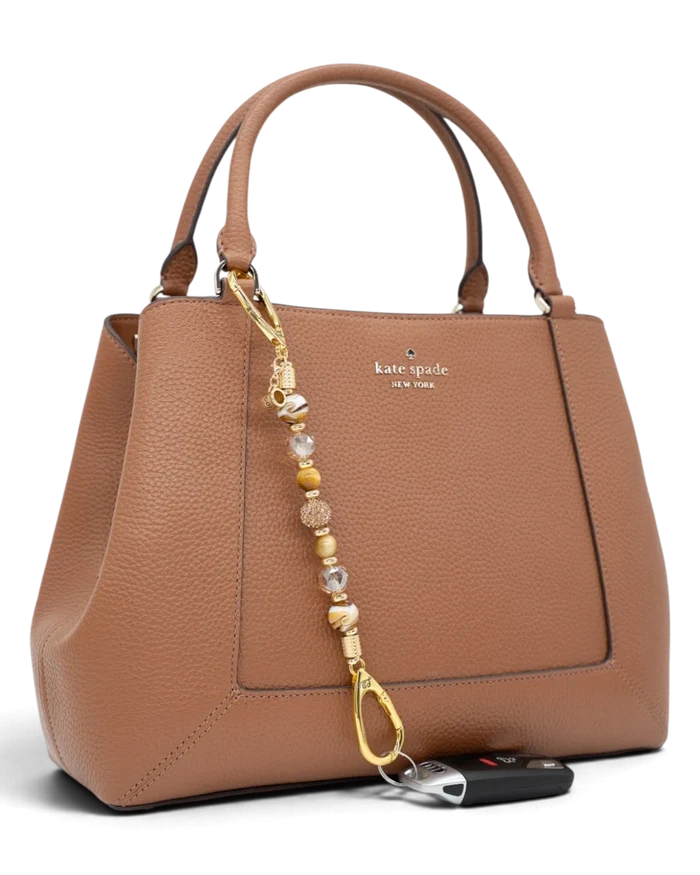 LD Keyfinder Caramel Latte beaded keychain with tiger eye and lampwork glass beads attached to a tan leather handbag.