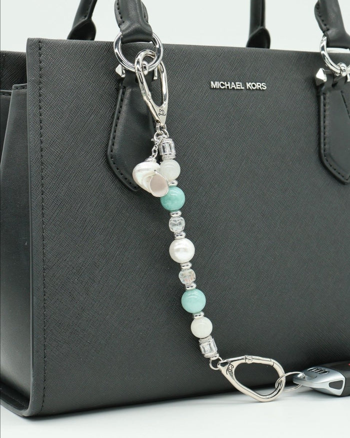 LD Keyfinder Caribbean Pearl beaded accessory with moonstone, aqua jade, and shell pearl charms attached to a black bag.