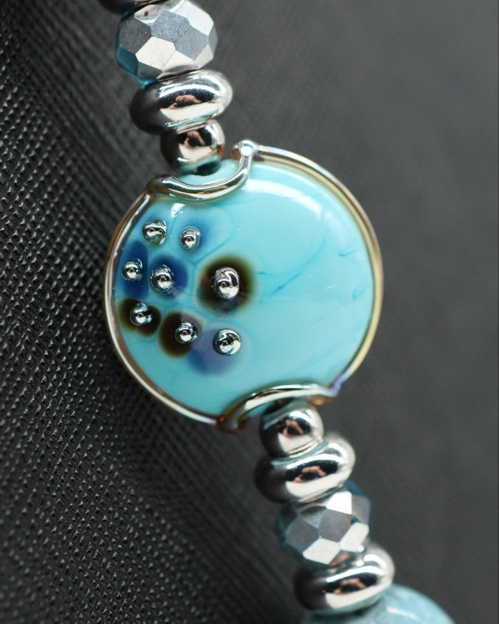 LD Keyfinder Celestial Tide necklace with handcrafted glass art bead, blue teal tiger eye, synthetic larimar, and silver accents.