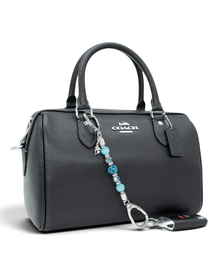 LD Keyfinder Dolphin Dream Mini beaded keychain with aqua glass beads and a rhinestone dolphin charm on a black bag.