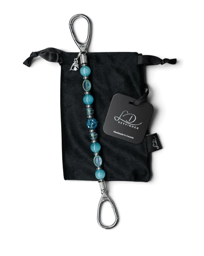 LD Keyfinder Dolphin Dream beaded key finder with aqua glass beads and a rhinestone dolphin charm on a velvet pouch.