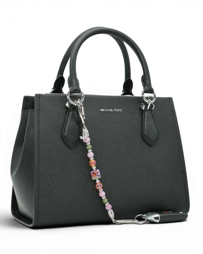 LD Keyfinder Dragonfly Magic charm with purple lepidolite, green jade, and orange glass beads on a black handbag.