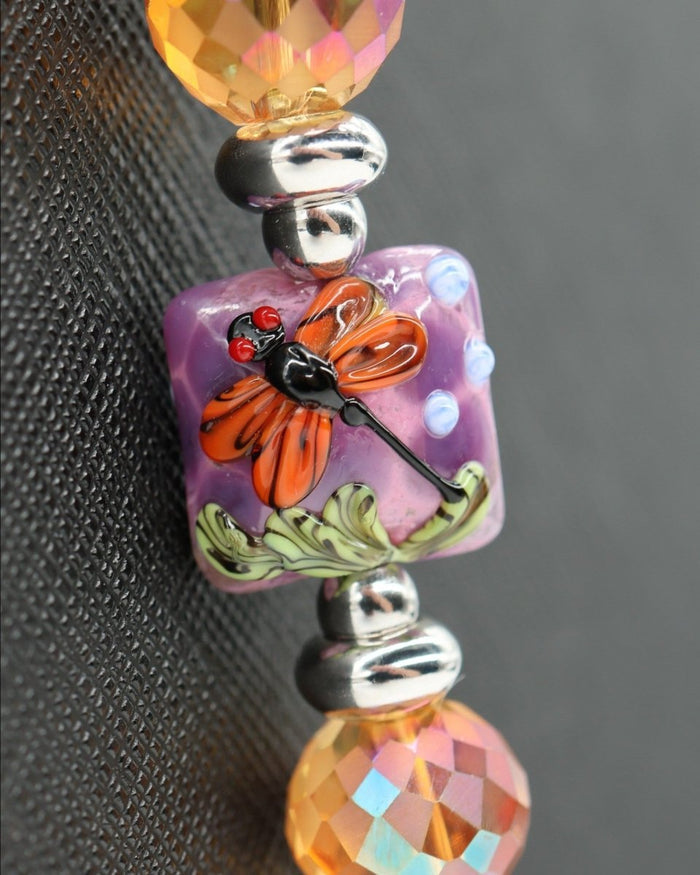 LD Keyfinder Dragonfly Magic bracelet with orange dragonfly lampwork bead, purple lepidolite, green jade, and orange faceted glass beads.