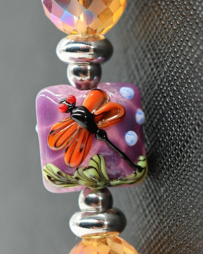 LD Keyfinder Dragonfly Magic bracelet with purple lampwork glass bead, orange dragonfly, faceted orange crystal beads, and silver spacers.