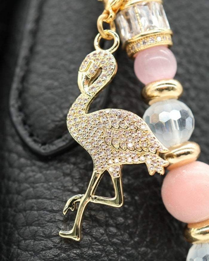 LD Keyfinder Flamingo Fantasy charm with pink opal, cat's eye beads, and gold-plated flamingo on a black leather bag