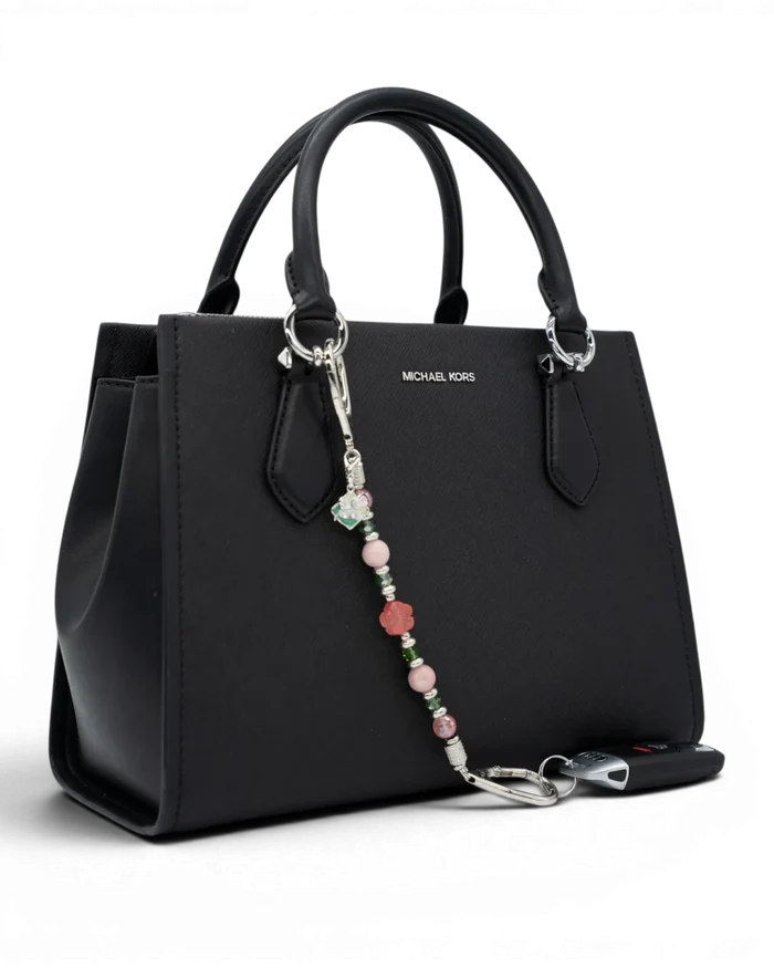 LD Keyfinder Garden Bliss beaded keychain with cherry quartz and pink opal attached to a black Michael Kors handbag.