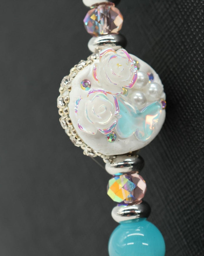 LD Keyfinder Garden Serenade artisan clay bead with floral and butterfly details, freshwater pearls, and aqua beads.