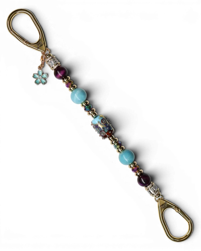 LD Keyfinder Gilded Fantasy keychain with sky blue and topaz glass art bead, larimar, purple tiger eye, gold-plated beads, and blue flower charm.