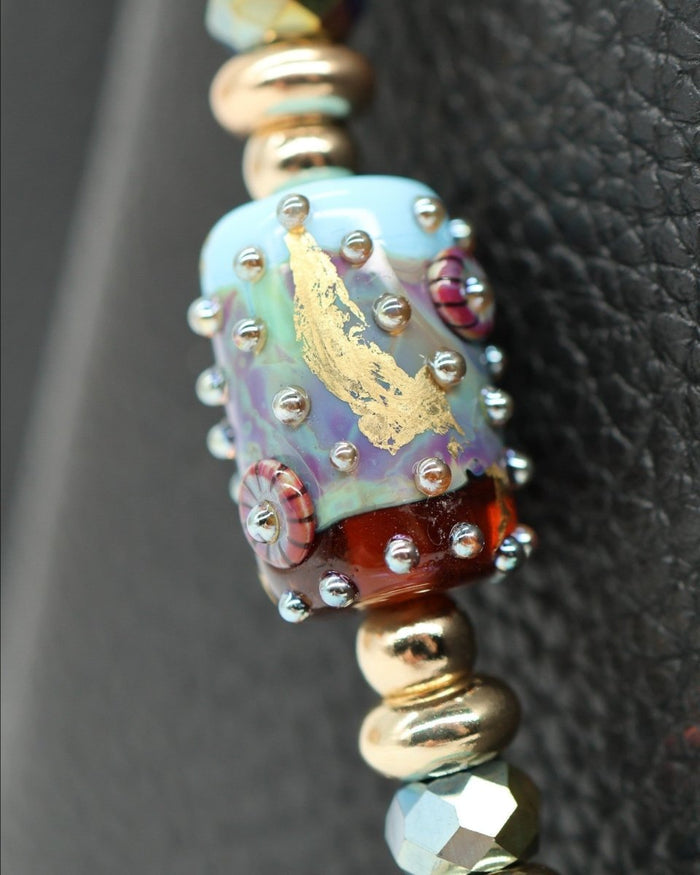 LD Keyfinder Gilded Fantasy bracelet with handcrafted glass art bead, sky blue, topaz, gold leaf, purple tiger eye, larimar, and gold-plated accents.