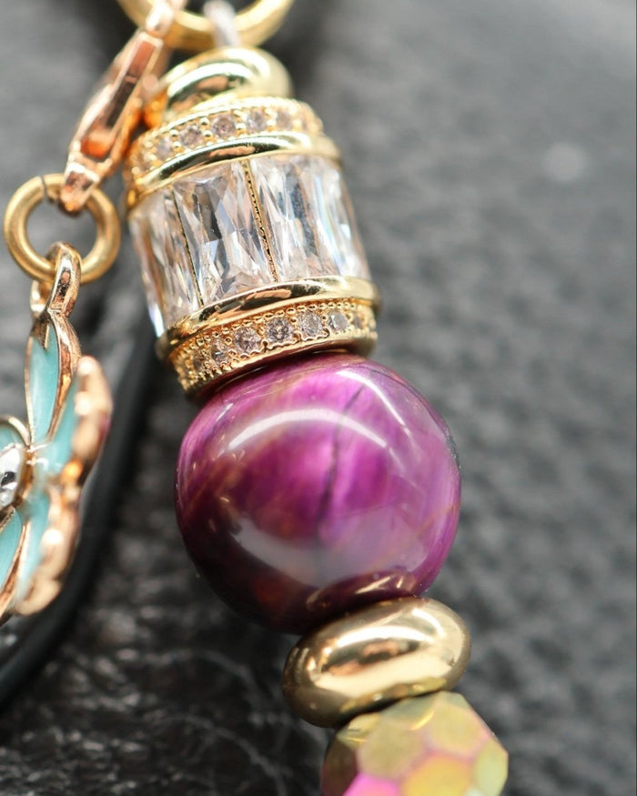 LD Keyfinder Gilded Fantasy bracelet with purple tiger eye, gold beads, and a blue flower charm.