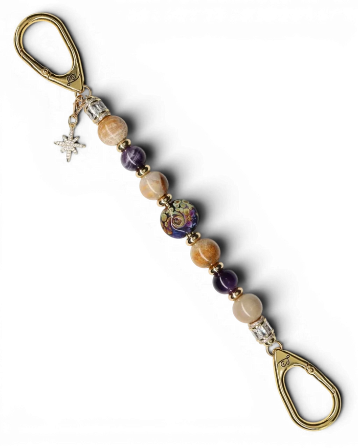 LD Keyfinder Golden Nebula keychain with purple and gold artisan glass bead, fossil coral, amethyst, and gold-plated star charm.