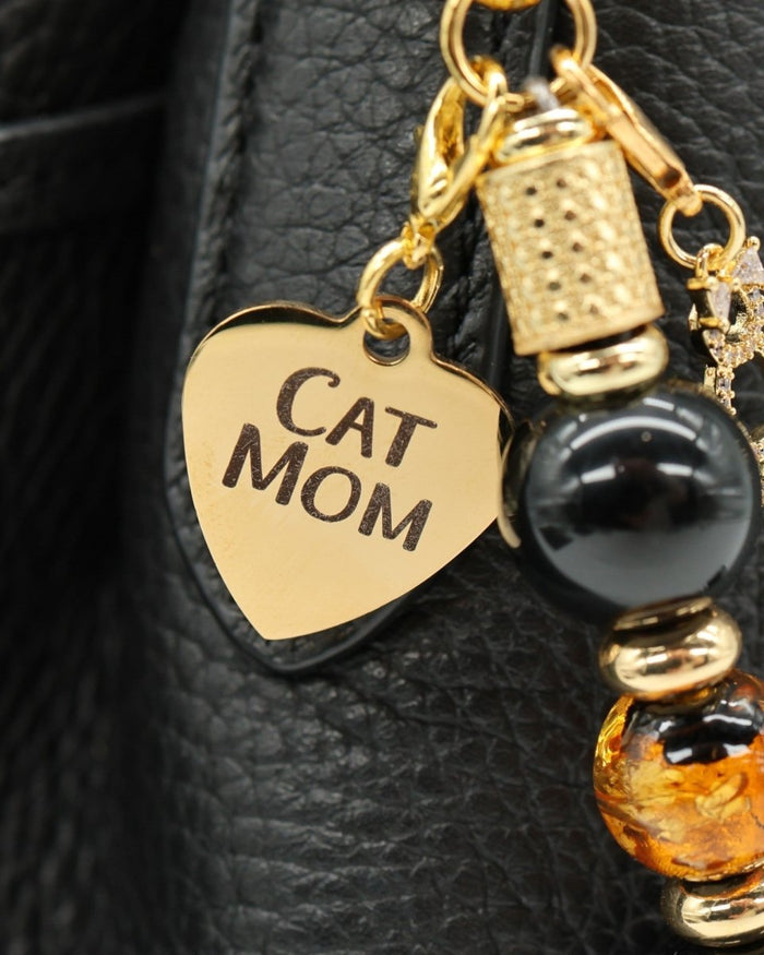 LD Keyfinder Golden Purrs accessory featuring a gold Cat Mom heart charm, black obsidian, and gold foil glass beads.