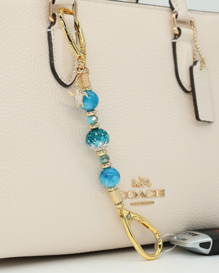 LD Keyfinder Golden Reef Mini keychain with aqua hemimorphite beads, crystal bead, starfish and turtle charms, 18KT gold-plated accents.