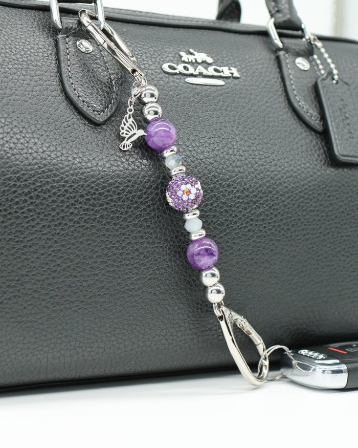 LD Keyfinder Hummingbird Dream Mini keychain with amethyst, crystal daisy bead, and hummingbird charm on black bag.