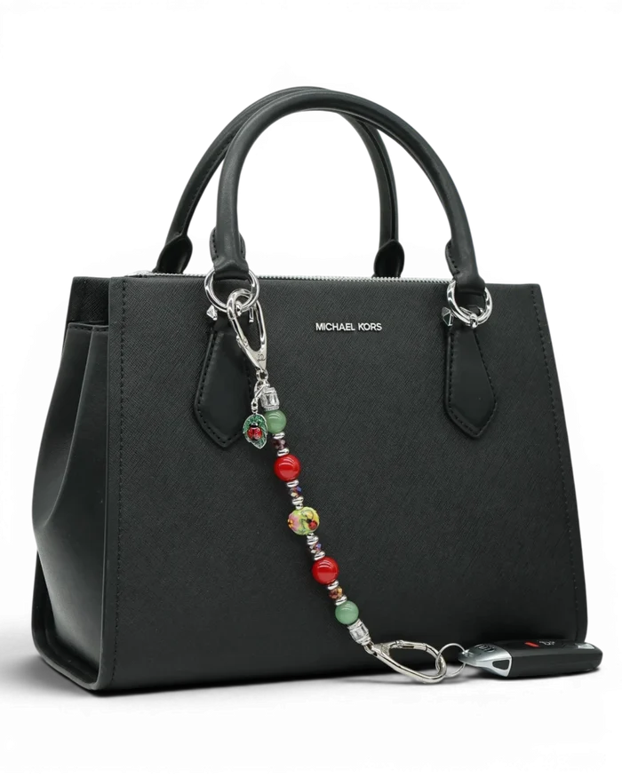 LD Keyfinder Ladybug Love beaded keychain with artisan glass, aventurine, and red shell pearls on a black handbag.