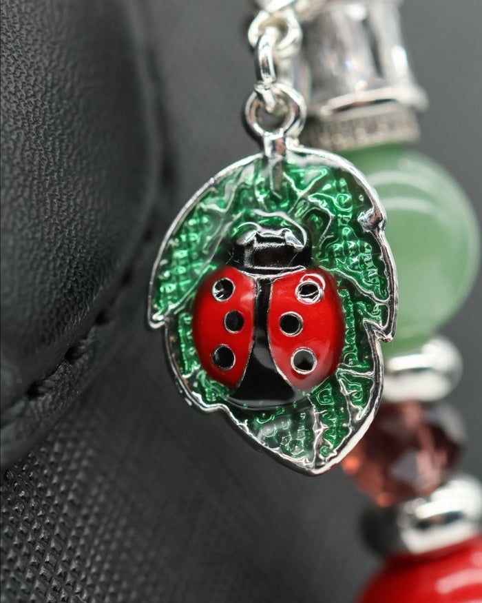LD Keyfinder Ladybug Love charm featuring a silver-plated ladybug on a leaf with green aventurine and red pearl beads.
