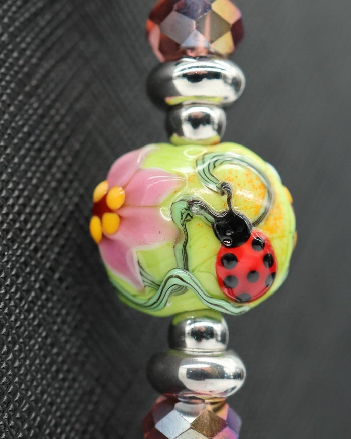 LD Keyfinder Ladybug Love artisan glass bead with floral design, red shell pearls, and green aventurine accents.
