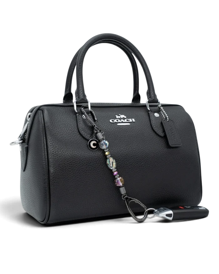 LD Keyfinder Midnight Aurora-Mini beaded charm with abalone and rainbow crystals attached to a black leather handbag