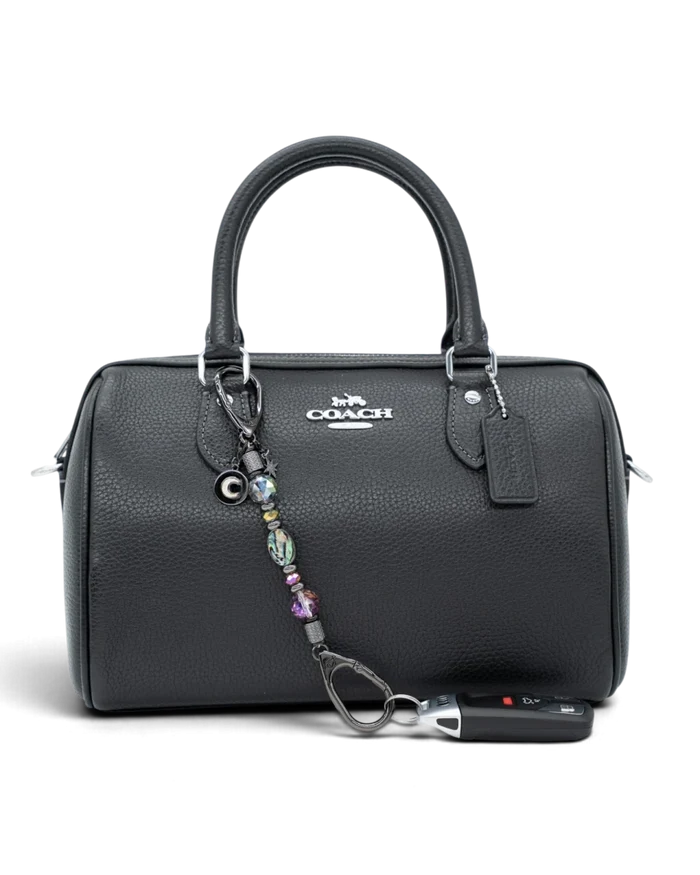 LD Keyfinder Midnight Aurora-Mini beaded keychain with abalone shell and rainbow crystals attached to a black handbag.