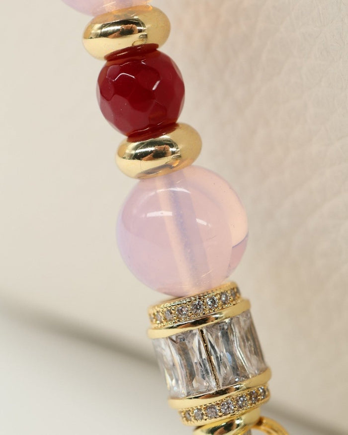 LD Keyfinder Opalite Bloom bracelet with pink opalite, ruby, and gold-plated beads, and a hummingbird charm.