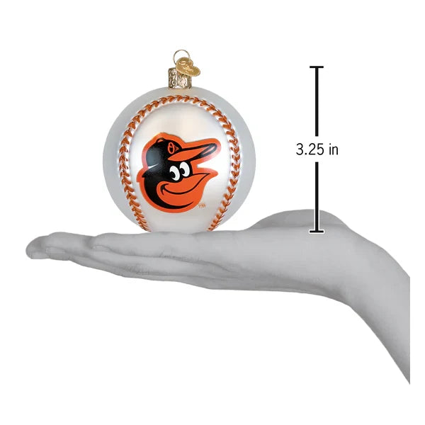 Glass ornament shaped like a baseball with a Orrioles logo, held in a hand to show size.