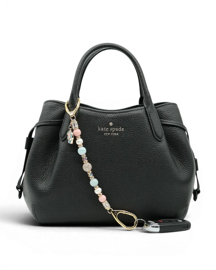 LD Keyfinder Pastel Garden charm with pink opal, freshwater pearls, aquamarine, and gold-plated beads on a black handbag.