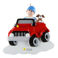 Decorative ornament with a boy driving a red off road vehicle and a dog on a white background