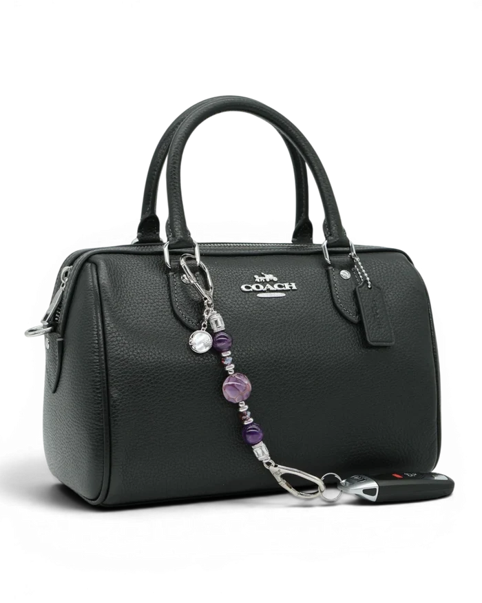 LD Keyfinder Petite Amethyst Moon keychain with genuine amethyst beads, artisan glass, and moon charm on a black handbag.