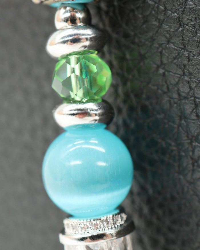 Petite Azure Meadow bracelet with aqua cat's eye, green faceted glass, and lampwork daisy beads. Platinum accents.