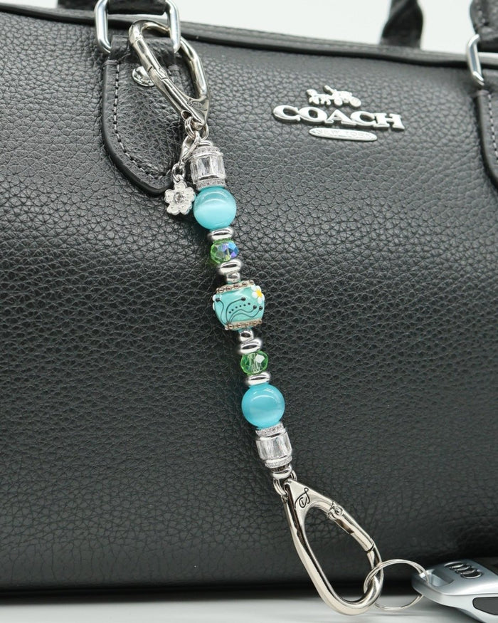LD Keyfinder Petite Azure Meadow keychain with aqua blue cat's eye beads, green glass beads, and a lampwork daisy bead.