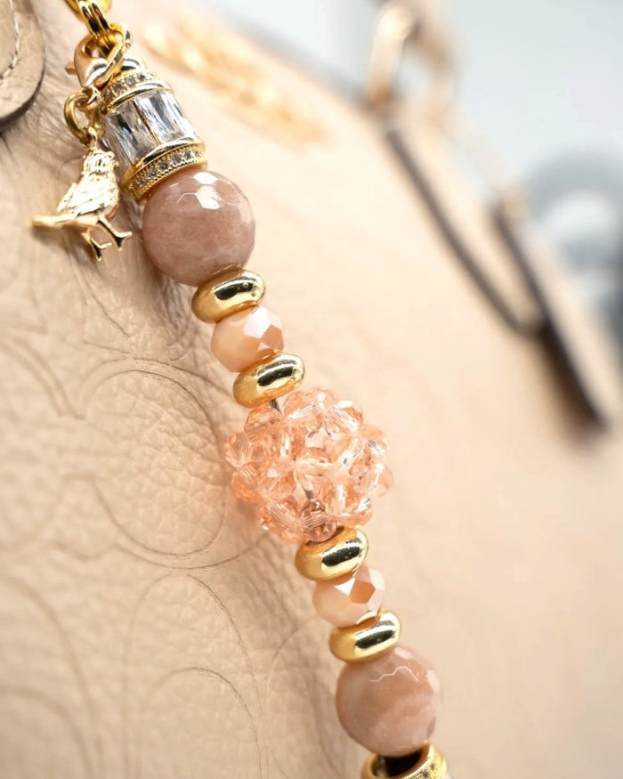 LD Keyfinder Petite Birdsong Bliss featuring peach glass, sunstone beads, and a gold-plated bird charm on a key clip.