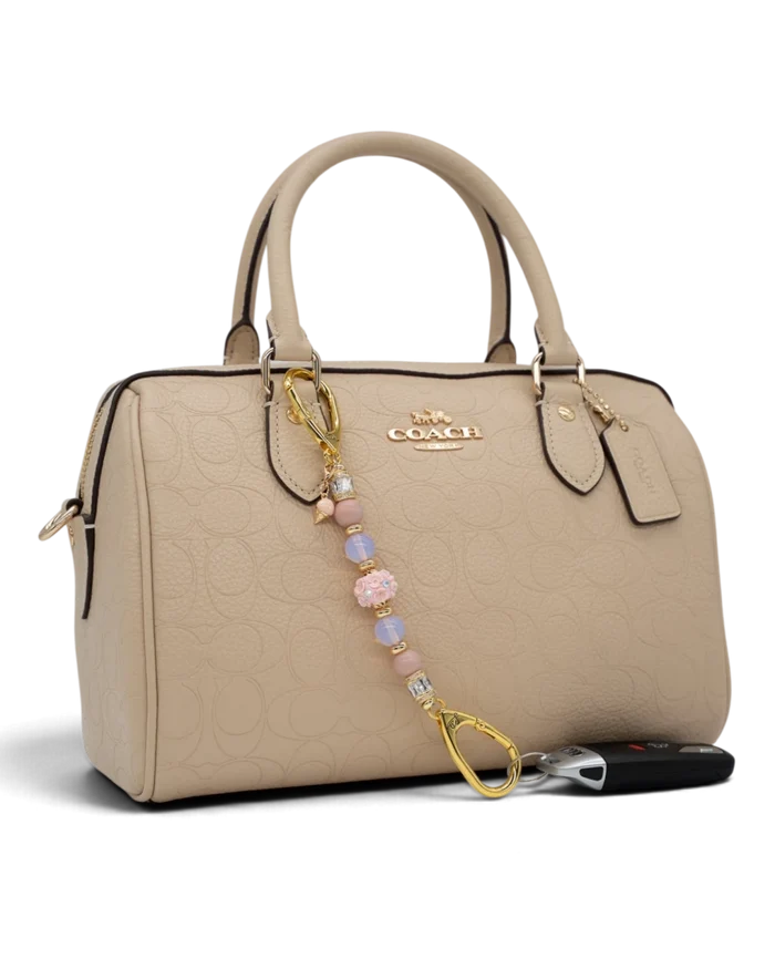LD Keyfinder Petite Blush Sorbetto beaded keychain with pink opal, opalite, and floral charm on a beige handbag