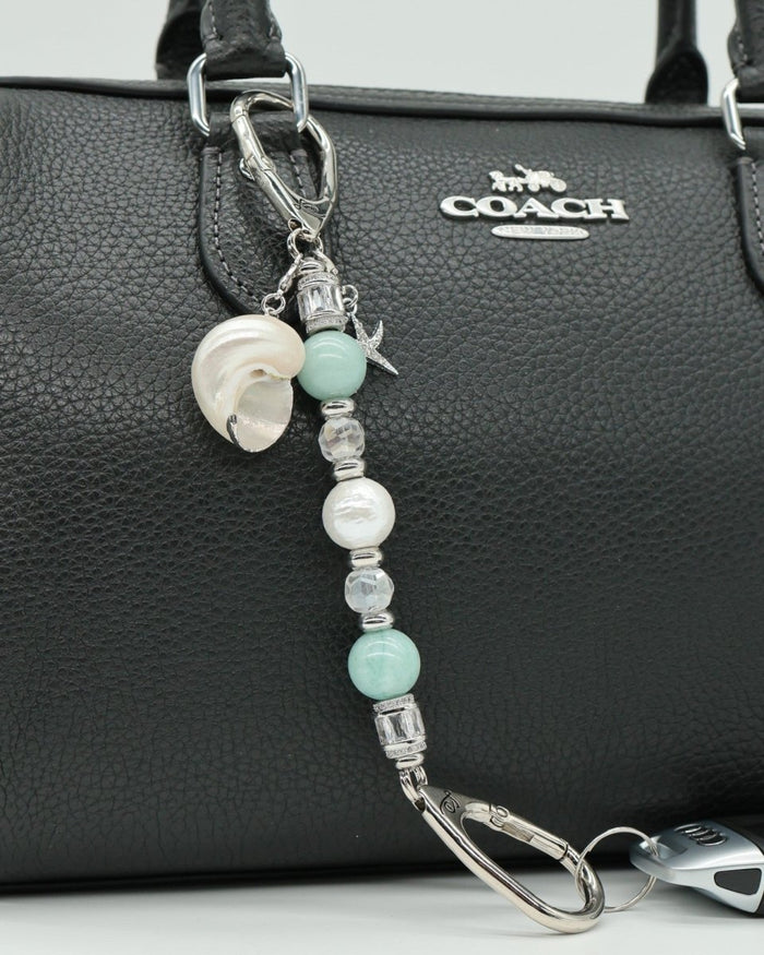LD Keyfinder Petite Caribbean Pearl beaded accessory with aqua jade, shell pearl, and starfish charm on a black bag.