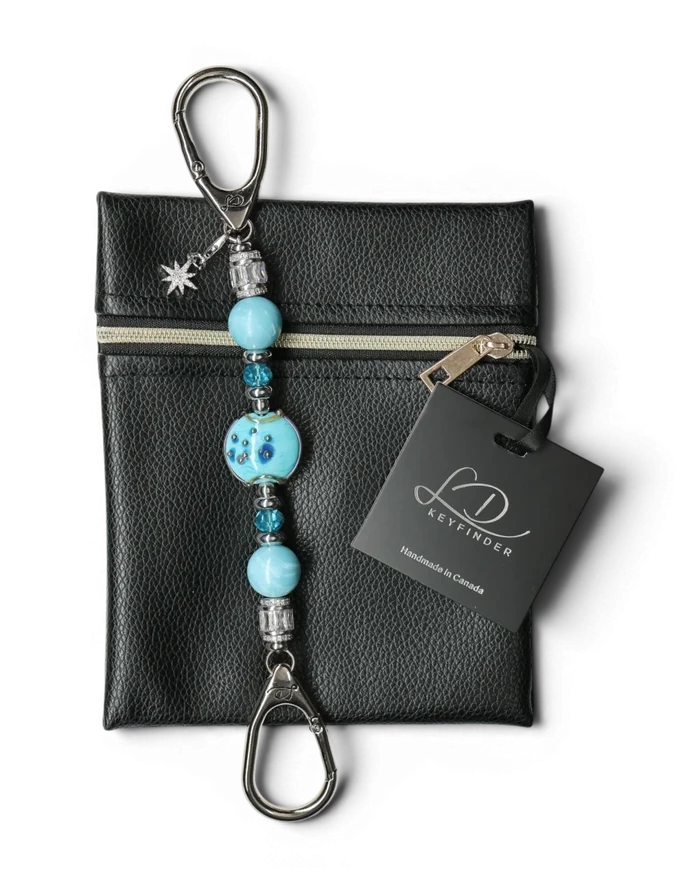 LD Keyfinder Petite Celestial Tide keychain with turquoise glass art bead, larimar, and silver accents, attached to a black pouch.