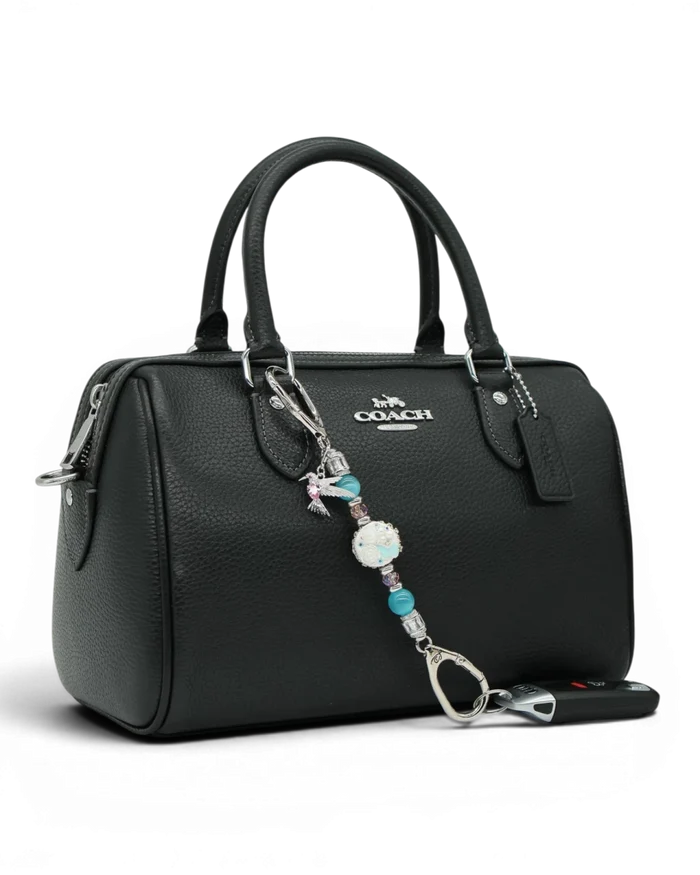LD Keyfinder Petite Garden Serenade accessory with aqua and pink beads and a hummingbird charm on a black handbag.
