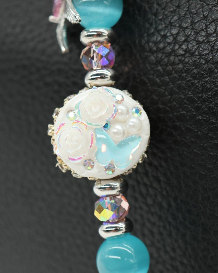 LD Keyfinder Petite Garden Serenade featuring an artisan clay bead with flowers, butterfly, aqua cat's eye, and crystals