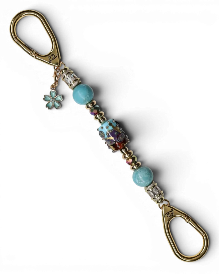 LD Keyfinder Petite Gilded Fantasy keychain with sky blue and topaz glass art bead, larimar, gold-plated accents, and flower charm.