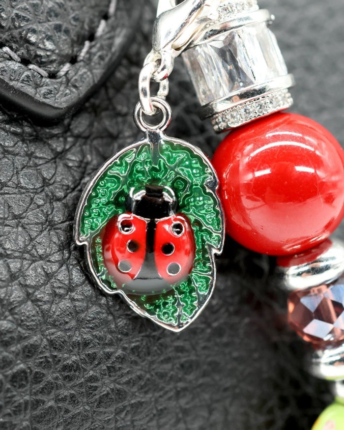 LD Keyfinder Petite Ladybug Love charm with red shell pearl, artisan glass bead, and silver-plated ladybug on leaf.