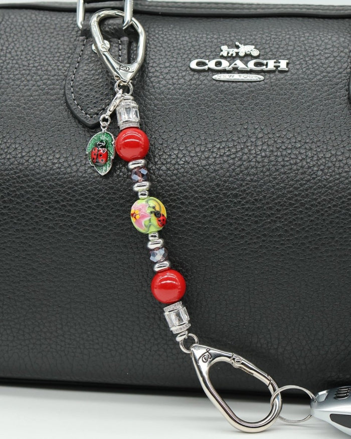 LD Keyfinder Petite Ladybug Love beaded keychain with red shell pearls, artisan glass bead, and ladybug charm on bag.