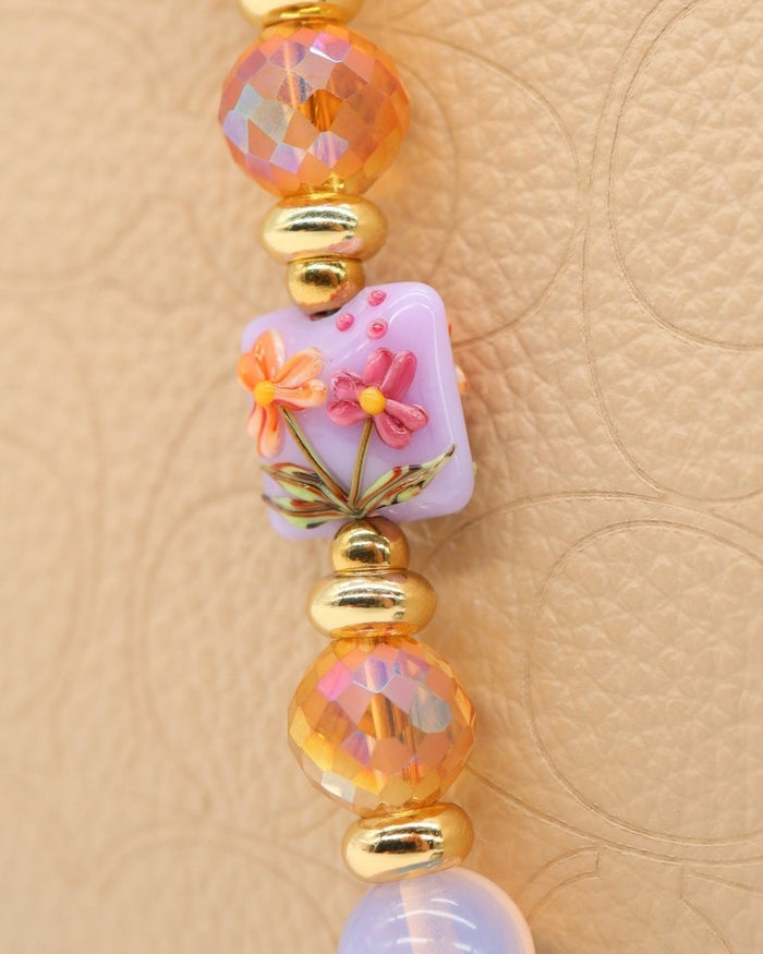 LD Keyfinder Petite Opalite Bloom bracelet with pink opalite, orange glass, and floral lampwork beads, gold accents, and hummingbird charm.