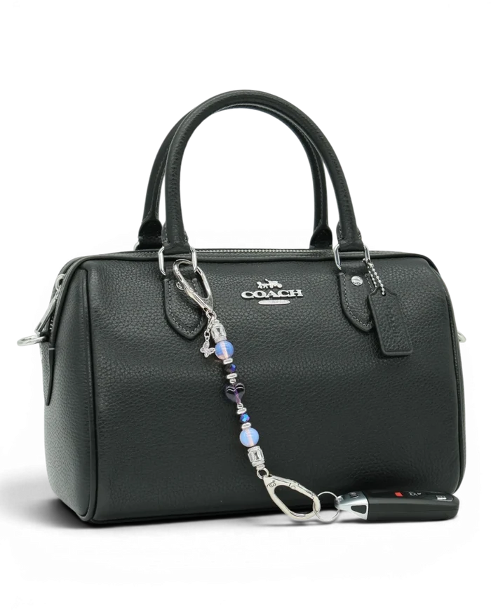 LD Keyfinder Petite Orchid Flutter accessory with pink opalite and purple glass beads attached to a black handbag.