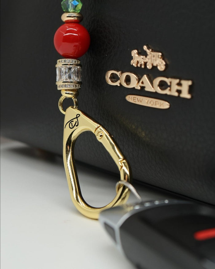 LD Keyfinder Petite Strawberry Fields key accessory with red crystal strawberry, shell pearls, and gold-plated charm.